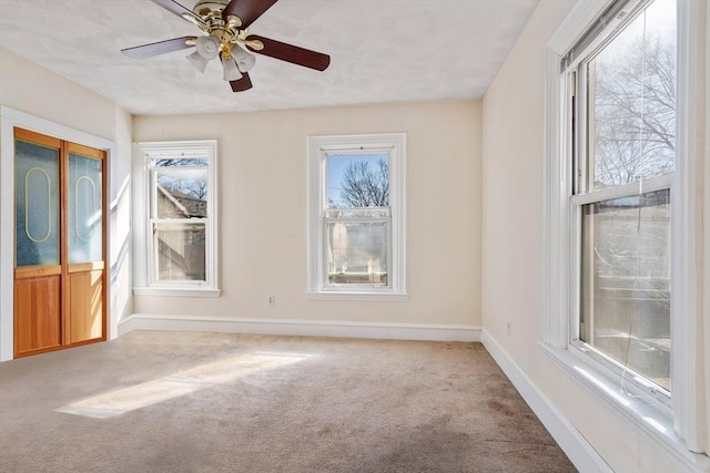 spare room with a ceiling fan, carpet, and baseboards