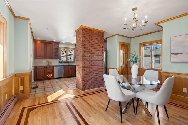 dining space with baseboard heating, wainscoting, and plenty of natural light