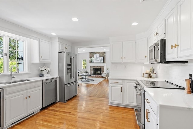 21 Johnson Rd, Winchester, MA 01890 - kitchen with appliances with stainless steel finishes, a sink, white cabinetry, a fireplace, and recessed lighting