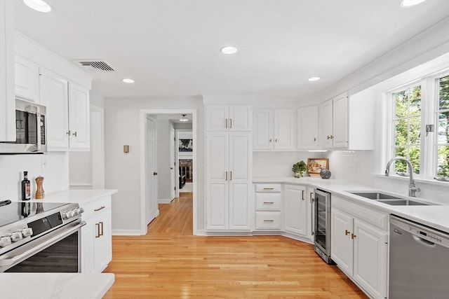 21 Johnson Rd, Winchester, MA 01890 - kitchen with appliances with stainless steel finishes, a sink, beverage cooler, decorative backsplash, and recessed lighting