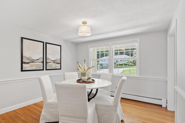 21 Johnson Rd, Winchester, MA 01890 - dining area with a baseboard radiator, light wood-style floors, and a textured ceiling