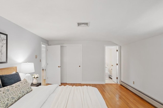 21 Johnson Rd, Winchester, MA 01890 - bedroom featuring a baseboard heating unit, wood finished floors, a closet, ensuite bathroom, and baseboards