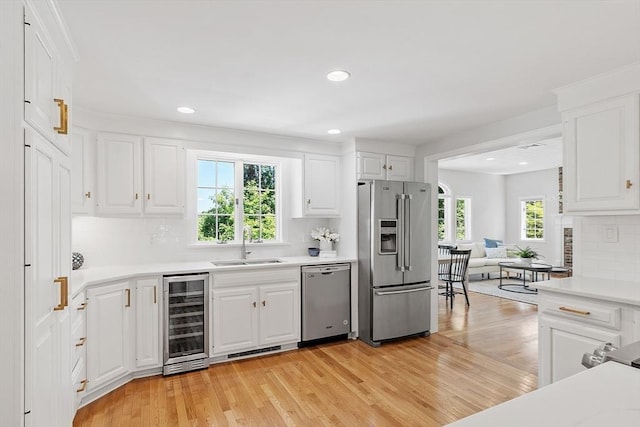 21 Johnson Rd, Winchester, MA 01890 - kitchen featuring stainless steel appliances, beverage cooler, a sink, decorative backsplash, and light countertops