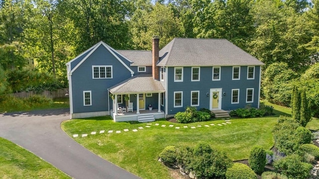 172 Carolyn Cir, Marshfield, MA 02050 - colonial-style house featuring a porch, a chimney, a front yard, and view of wooded area