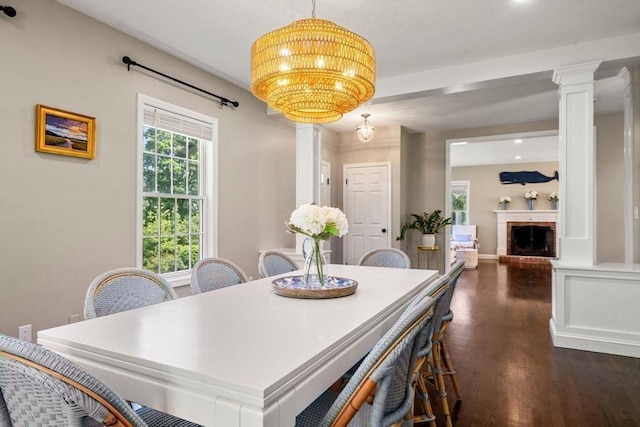 172 Carolyn Cir, Marshfield, MA 02050 - dining space featuring decorative columns, dark wood-type flooring, a brick fireplace, and a chandelier