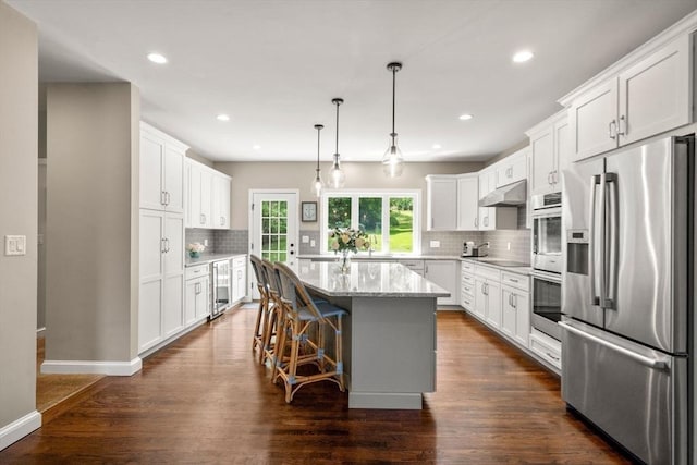 172 Carolyn Cir, Marshfield, MA 02050 - kitchen featuring stainless steel fridge with ice dispenser, under cabinet range hood, beverage cooler, backsplash, and a center island