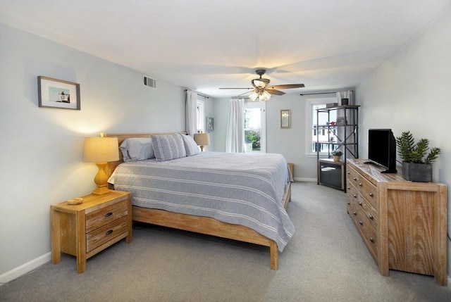 bedroom with visible vents, a ceiling fan, baseboards, and light colored carpet