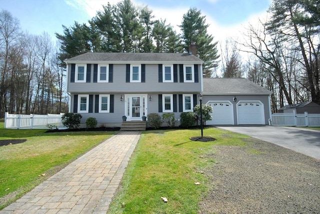 colonial home featuring a garage, fence, driveway, and a chimney