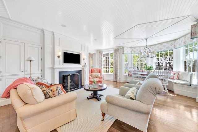 living room with light hardwood / wood-style floors and a notable chandelier