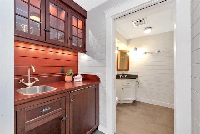 bar featuring wood walls and sink