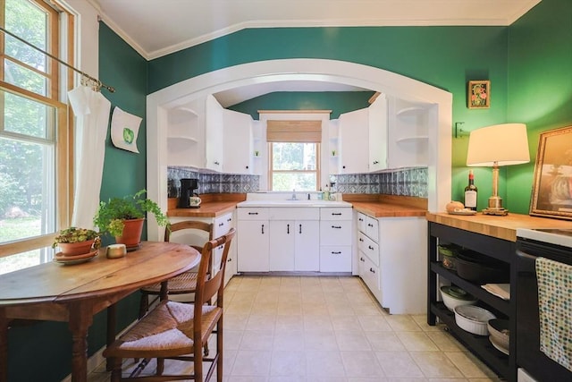 5 Pleasant St, Bourne, MA 02532 - kitchen with open shelves, ornamental molding, butcher block countertops, backsplash, and white cabinets
