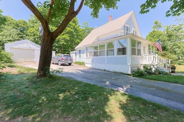 5 Pleasant St, Bourne, MA 02532 - view of home's exterior with an outdoor structure, a chimney, asphalt driveway, a garage, and a lawn