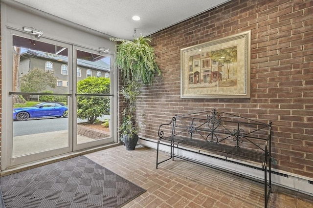 29 Vine St Unit 8, Winchester, MA 01890 - doorway featuring brick patterned floors, brick wall, a textured ceiling, and recessed lighting