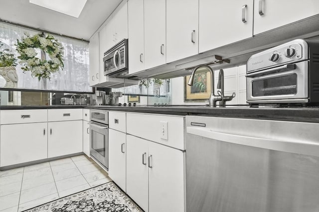 29 Vine St Unit 8, Winchester, MA 01890 - kitchen with appliances with stainless steel finishes, white cabinets, and dark countertops