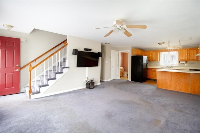 unfurnished living room featuring ceiling fan and light carpet