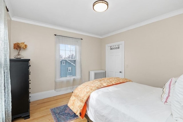 bedroom featuring crown molding, wood finished floors, and baseboards