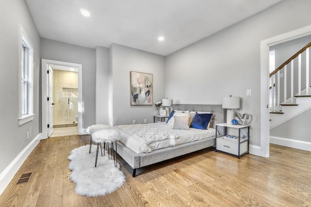 bedroom with visible vents, baseboards, connected bathroom, wood finished floors, and recessed lighting