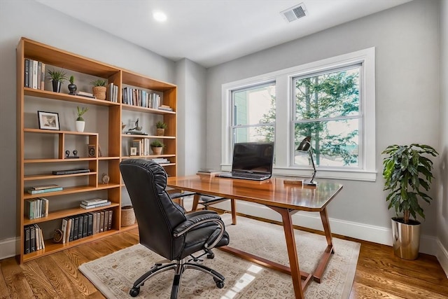 office with wood finished floors, visible vents, and baseboards