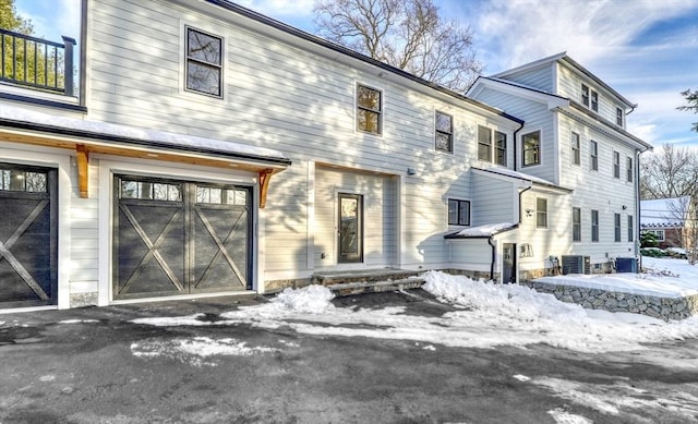 view of front of house with central AC and an attached garage