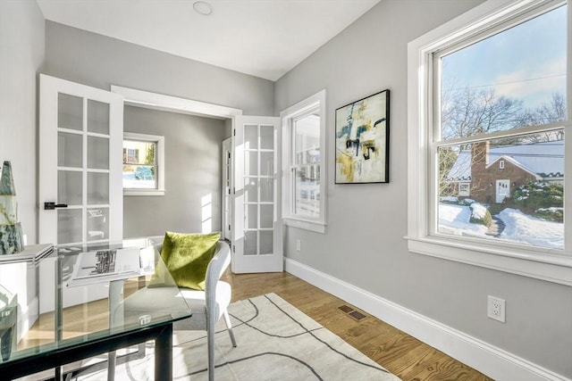 office featuring french doors, plenty of natural light, wood finished floors, and baseboards