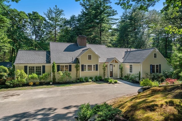 view of front of home with driveway and a chimney