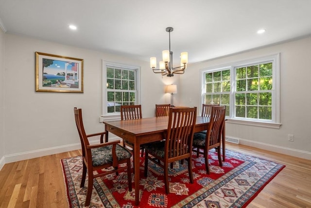 dining room with a notable chandelier, visible vents, light wood-type flooring, and a wealth of natural light