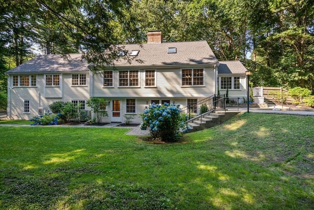 rear view of property with a yard and a chimney