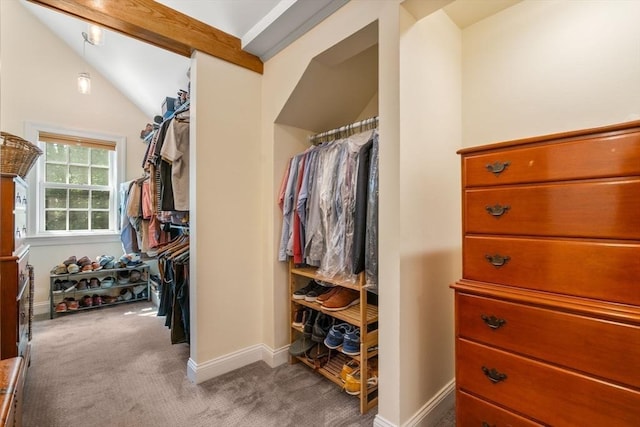 spacious closet with lofted ceiling with beams and carpet flooring