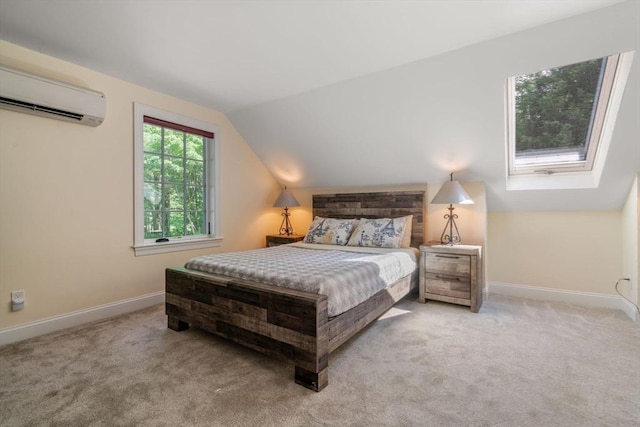 bedroom with a wall unit AC, baseboards, carpet floors, and lofted ceiling with skylight