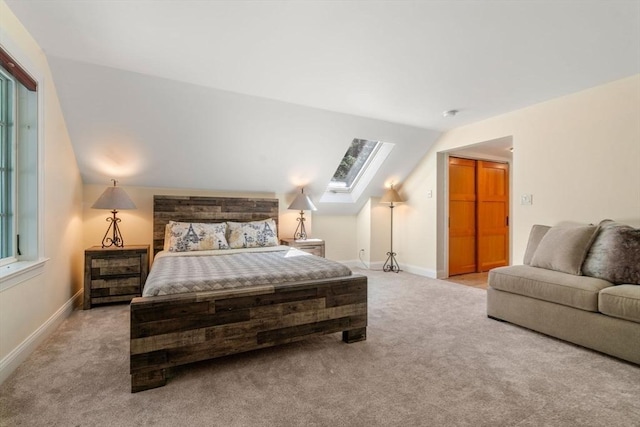 carpeted bedroom with lofted ceiling with skylight and baseboards