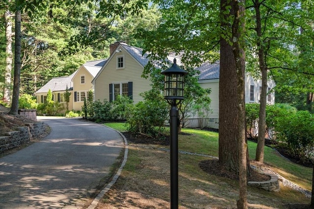 view of front of home with aphalt driveway and roof with shingles