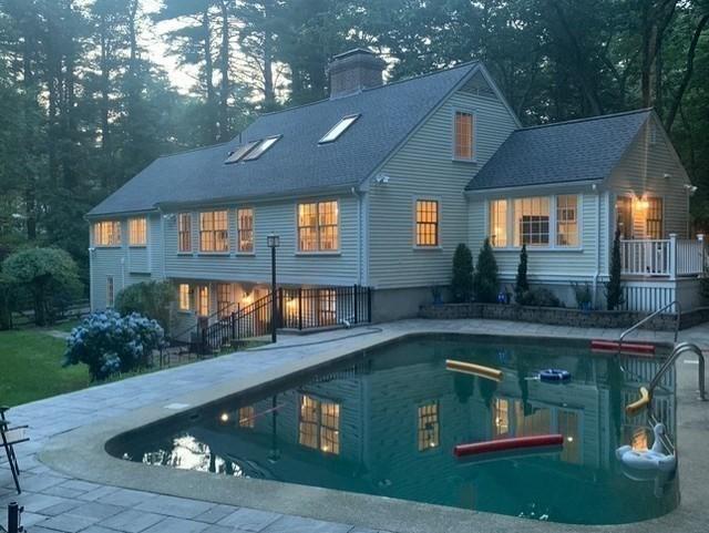 rear view of property featuring an outdoor pool and a chimney