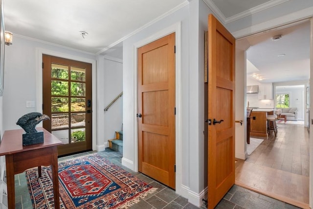 entryway with crown molding, stairway, and baseboards