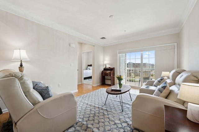 living area featuring crown molding, wood finished floors, and baseboards