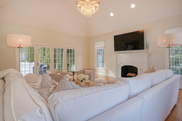 living room with wood-type flooring, lofted ceiling, and an inviting chandelier