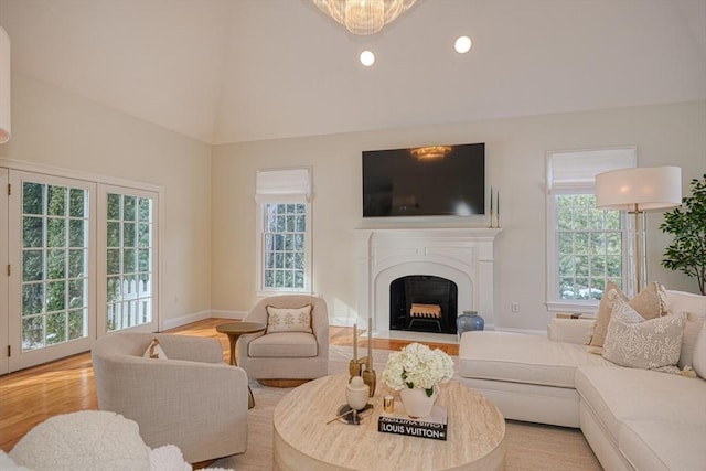 living room featuring lofted ceiling, plenty of natural light, and light hardwood / wood-style floors