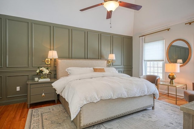 bedroom with multiple closets, ceiling fan, and light wood-type flooring