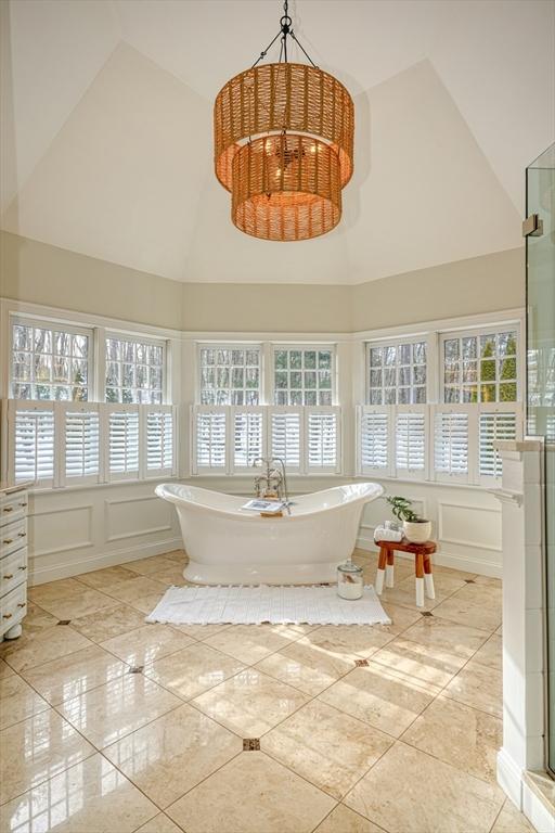 bathroom with plus walk in shower, plenty of natural light, and high vaulted ceiling