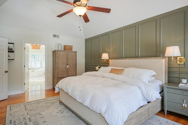 bedroom with ensuite bath, ceiling fan, and light hardwood / wood-style floors