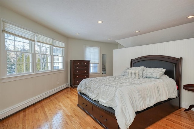 bedroom with light hardwood / wood-style flooring and baseboard heating