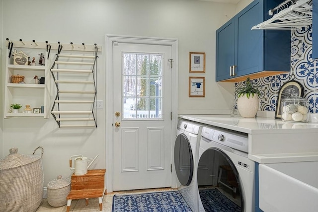 clothes washing area featuring cabinets and washer and clothes dryer