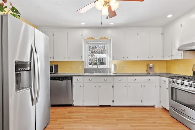 40 Flaggler Rd, Leominster, MA 01453 - kitchen with appliances with stainless steel finishes, white cabinetry, a ceiling fan, wall chimney exhaust hood, and light wood-type flooring