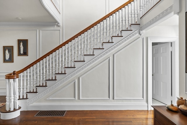 stairway featuring hardwood / wood-style floors and crown molding