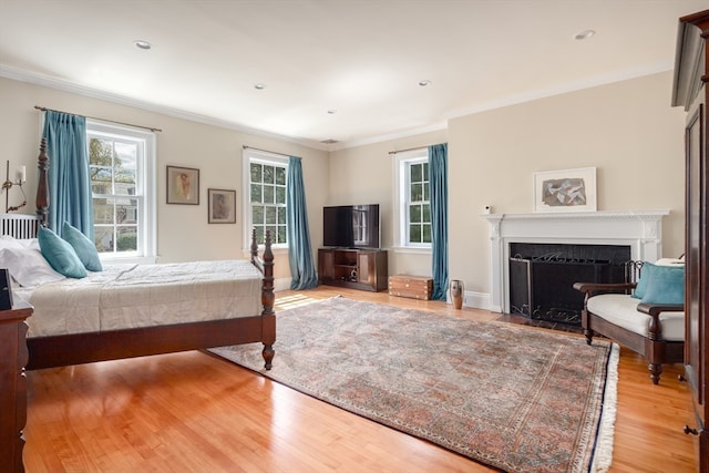 bedroom with light wood-type flooring and ornamental molding