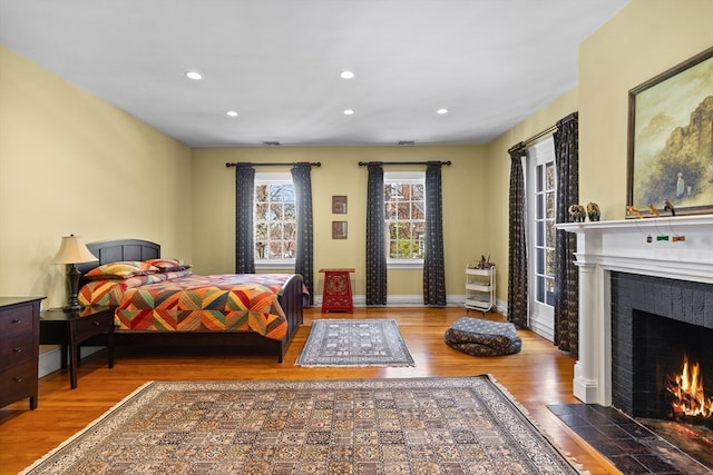 bedroom featuring a fireplace and dark hardwood / wood-style floors