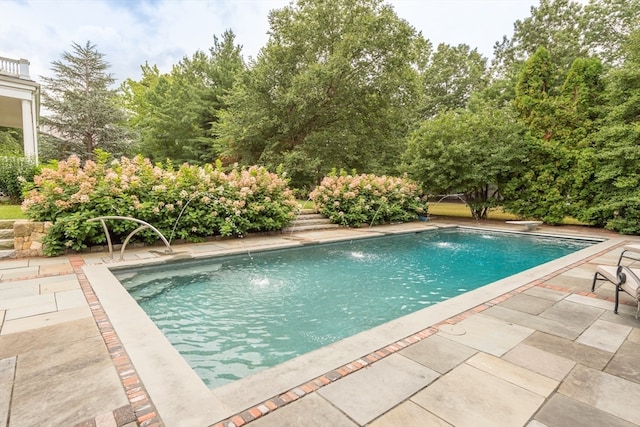 view of swimming pool featuring pool water feature and a patio area