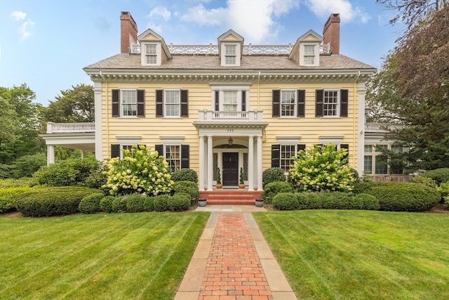 colonial house with a front yard and a balcony