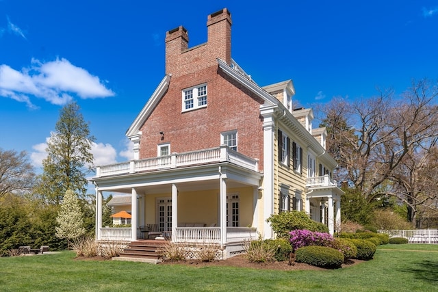 exterior space with a yard, a porch, and a balcony