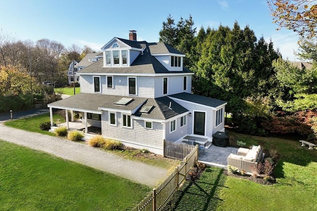 rear view of house with an outdoor living space, a patio area, and a yard