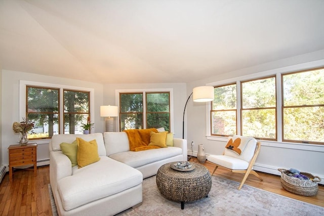 living room featuring wood-type flooring, baseboard heating, and lofted ceiling